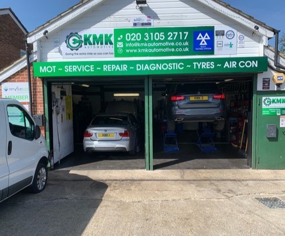 A car repair garage with a car inside, offering MOT servicing.